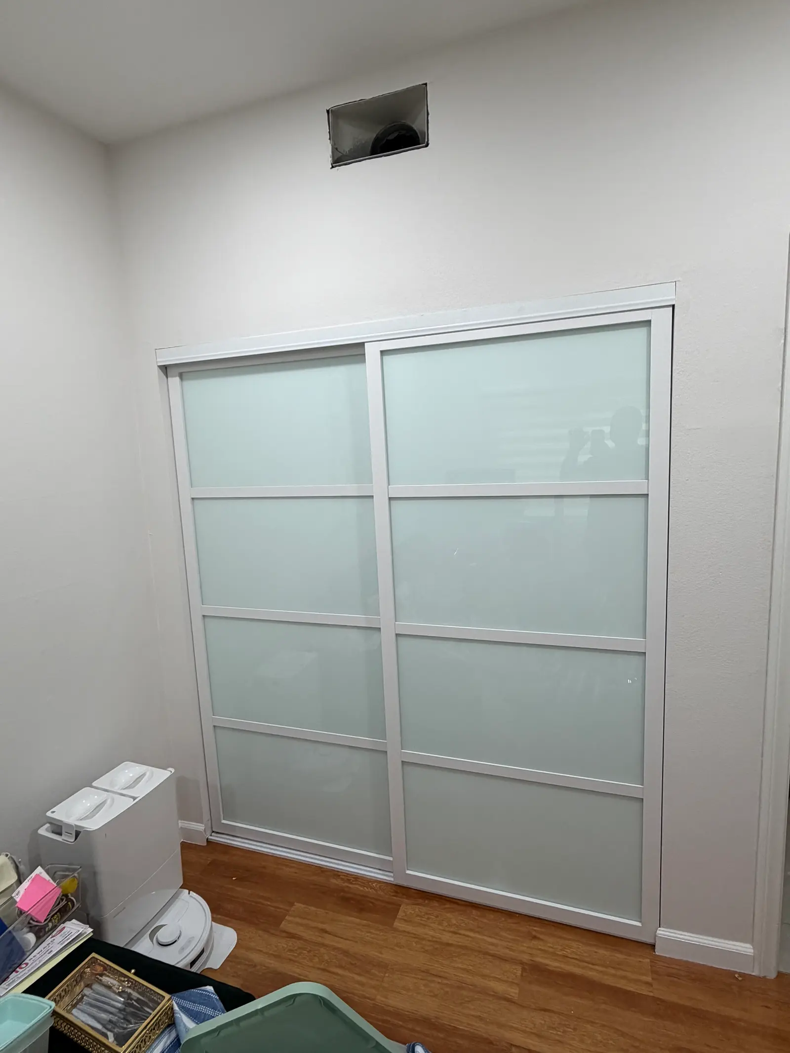 Sliding closet doors with a white frame and four frosted glass panels per leaf